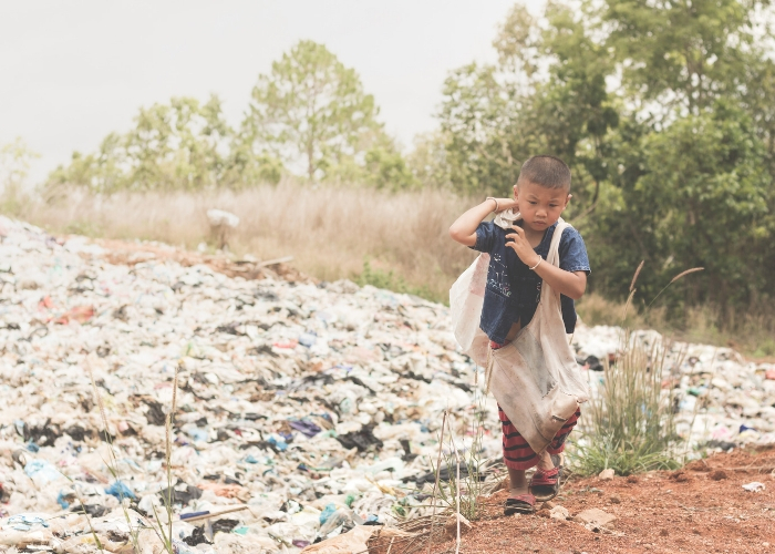 niño caminando entre basura